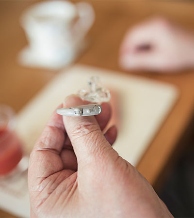 Senior Man Holding His Hearing Aid